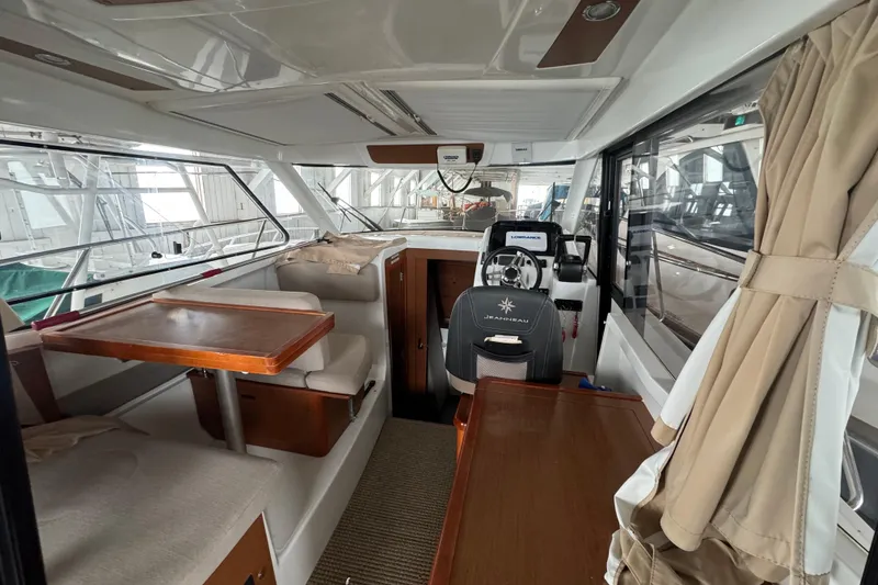 Slide: The Image of Interior of 2016 Jeanneau Merry Fisher 855 boat, featuring seating and helm station. - 12