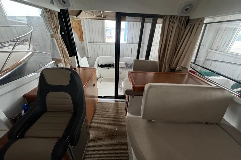 Slide: The Image of Interior of a 2016 Jeanneau Merry Fisher 855 boat, featuring seating and a table. - 15