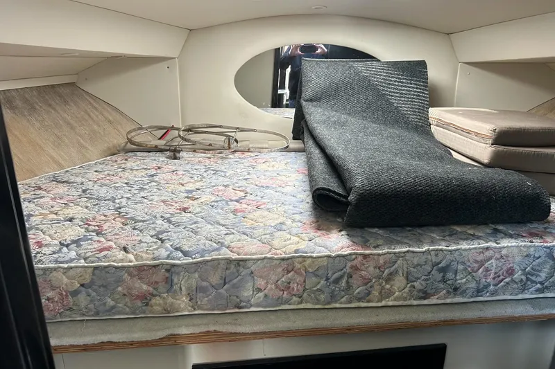 Slide: The Image of Interior cabin of 2003 Silverton 330 Sport Bridge with floral mattress and rolled carpet. - 10
