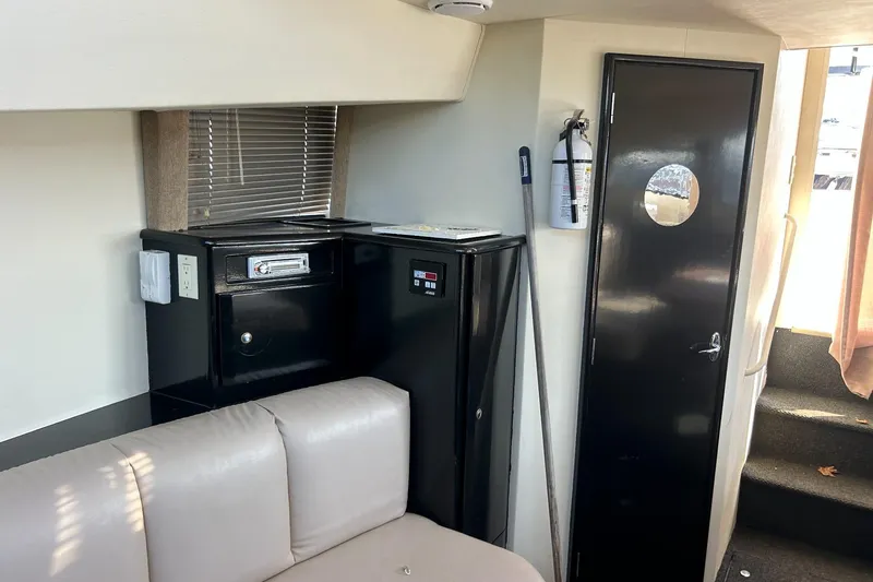 Slide: The Image of Interior of 2003 Silverton 330 Sport Bridge with beige seating and black cabinetry. - 12