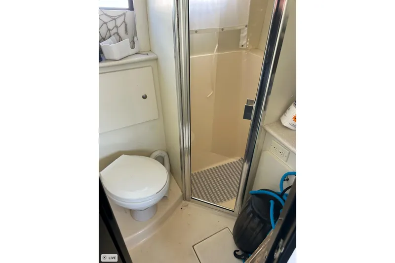 Slide: The Image of Bathroom interior of 2003 Silverton 330 Sport Bridge yacht, featuring toilet and shower. - 13