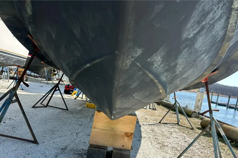 Slide: The Image of 2003 Silverton 330 Sport Bridge boat hull on stands by the water. - 14