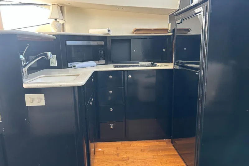 Slide: The Image of 2003 Silverton 330 Sport Bridge kitchen with sink, microwave, and cabinets. - 18