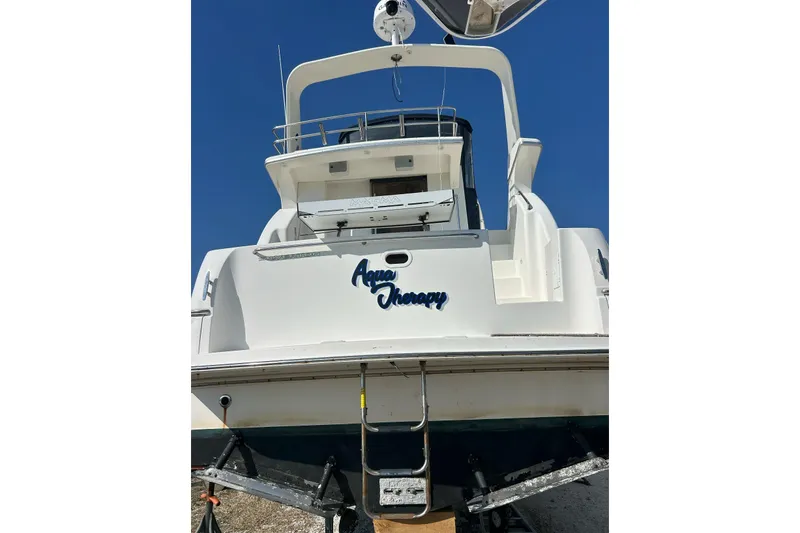 Slide: The Image of 2003 Silverton 330 Sport Bridge boat on trailer, rear view under clear blue sky. - 3