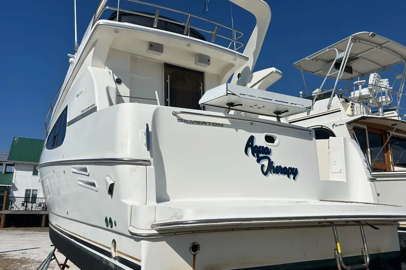 Slide: The Image of 2003 Silverton 330 Sport Bridge yacht named "Aqua Therapy" docked under clear blue sky. - 4