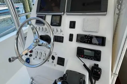 Slide: The Image of Control panel of a 2005 Stamas 310 Tarpon boat with steering wheel and navigation equipment. - 10