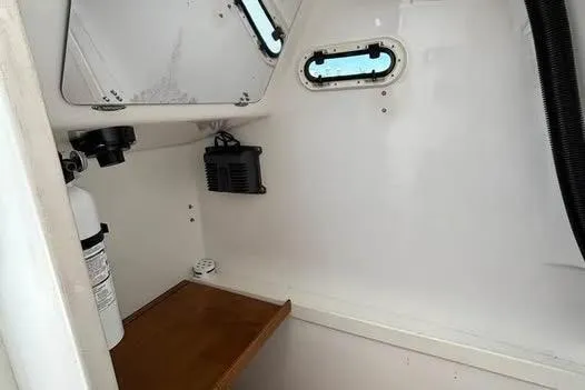Slide: The Image of Interior cabin of a 2005 Stamas 310 Tarpon boat, featuring a small window and fire extinguisher. - 5