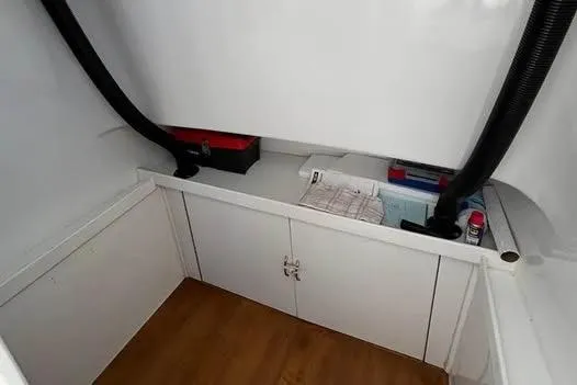 Slide: The Image of Interior storage area of a 2005 Stamas 310 Tarpon boat, featuring cabinets and equipment. - 6