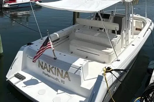 Slide: The Image of 2005 Stamas 310 Tarpon boat docked, featuring "NAKINA" and American flag. - 7