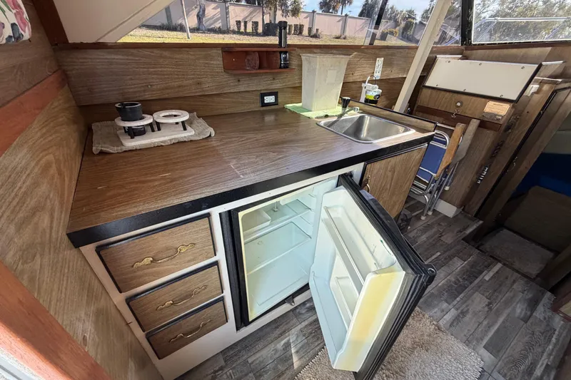 Slide: The Image of 1973 Chris-Craft 30 Tournament FB boat interior with kitchenette, sink, and open fridge. - 11