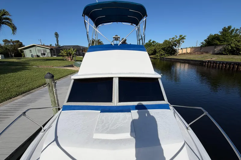 Slide: The Image of 1973 Chris-Craft 30 Tournament FB boat docked by a canal under clear blue skies. - 3