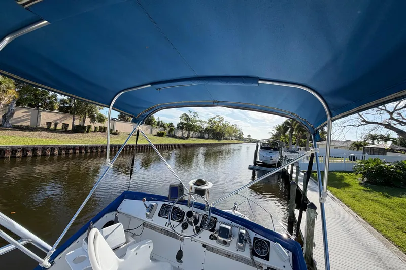 Slide: The Image of 1973 Chris-Craft 30 Tournament FB boat on a serene canal with blue canopy. - 9