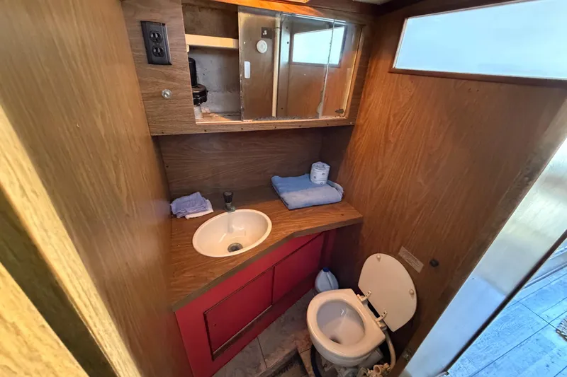 Slide: The Image of 1973 Chris-Craft 30 Tournament FB boat bathroom with sink, mirror, and toilet. - 15