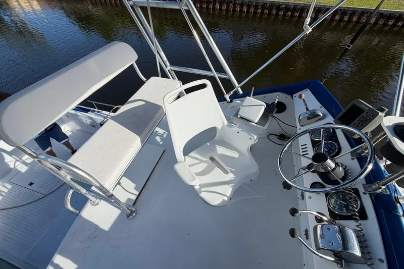 Slide: The Image of 1973 Chris-Craft 30 Tournament FB boat helm with steering wheel and seating, docked by water. - 7
