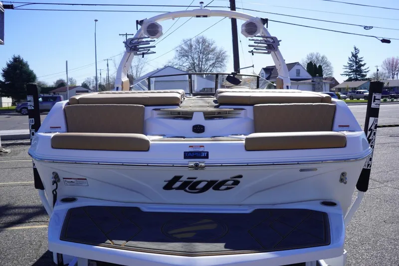 Slide: The Image of 2025 Tigé Z3 boat rear view with seating and wakeboard tower in a parking lot. - 10