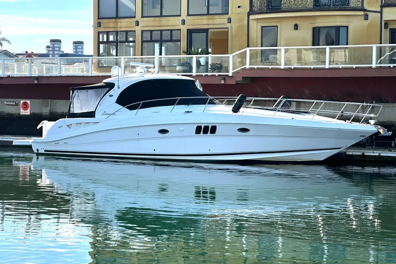 The Image of 2007 Sea Ray 440 Express yacht docked by waterfront buildings. - 0