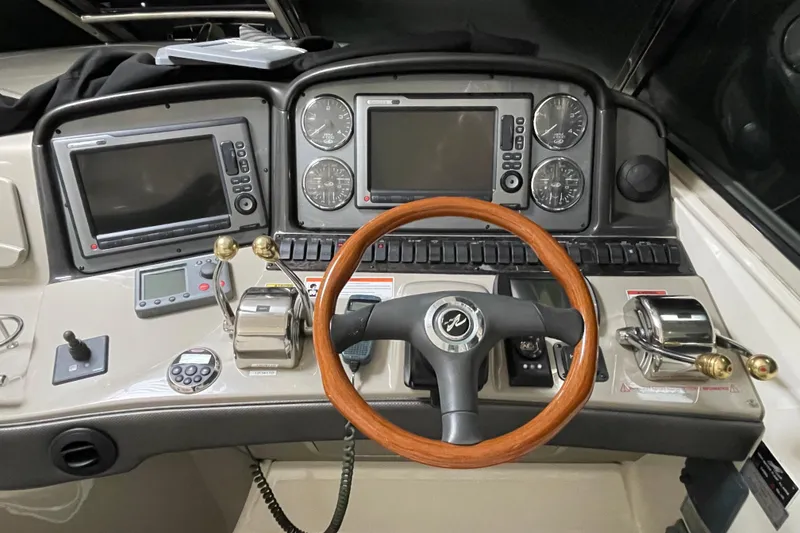 Slide: The Image of Cockpit of 2007 Sea Ray 440 Express with dual screens and wooden steering wheel. - 11