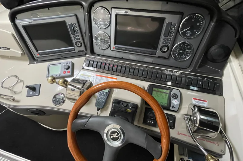 Slide: The Image of Cockpit of 2007 Sea Ray 440 Express with navigation instruments and wooden steering wheel. - 12
