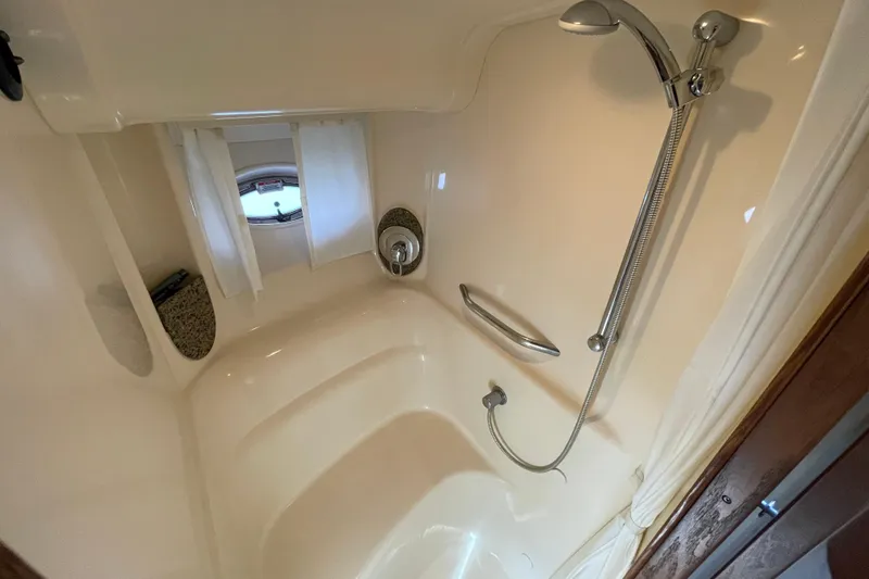 Slide: The Image of Luxurious shower area in 2007 Sea Ray 440 Express yacht, featuring modern fixtures and porthole window. - 50