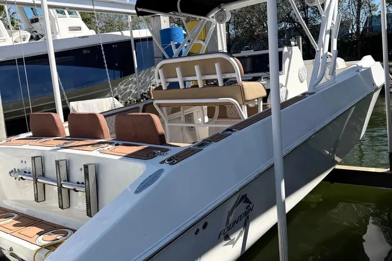 Slide: The Image of 1993 Fountain 31 Tournament Edition boat docked, featuring seating and fishing rod holders. - 10