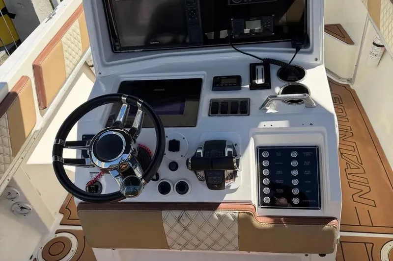 Slide: The Image of 1993 Fountain 31 Tournament Edition boat dashboard with steering wheel and control panel. - 3