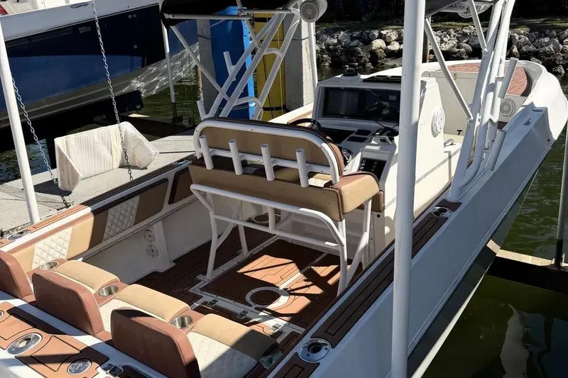 Slide: The Image of 1993 Fountain 31 Tournament Edition boat with beige seating and wood accents at a dock. - 6