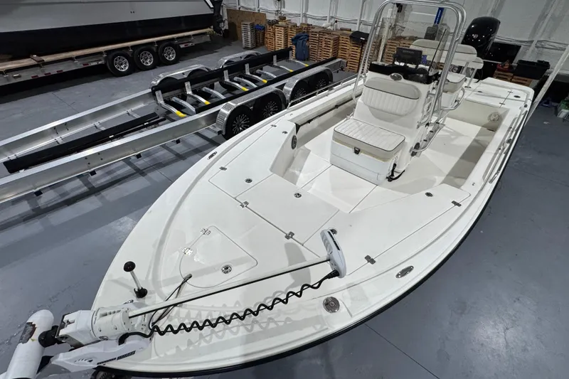 Slide: The Image of 2017 Mako 21 LTS boat in a showroom with trailer, featuring spacious seating and modern design. - 17