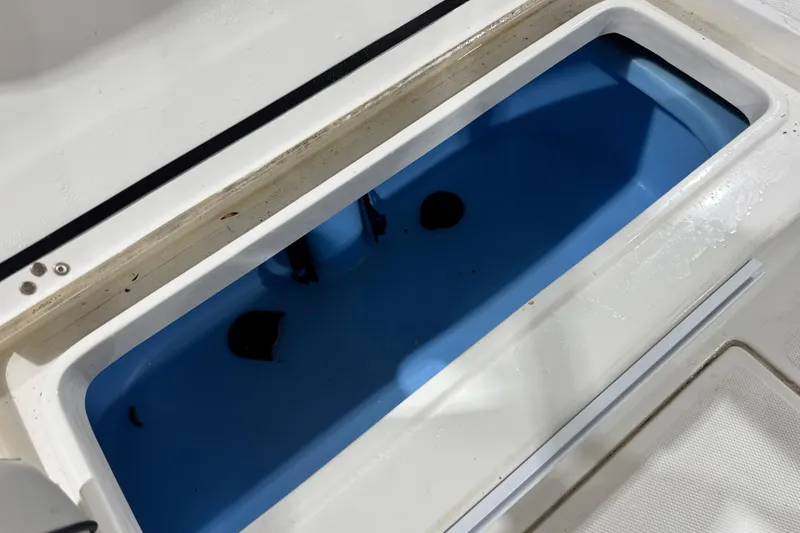 Slide: The Image of Livewell compartment in a 2017 Mako 21 LTS boat, featuring a blue interior. - 23