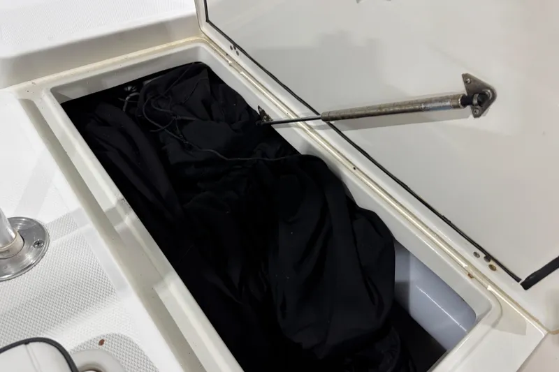 Slide: The Image of Open storage compartment on a 2017 Mako 21 LTS boat, containing black fabric. - 24