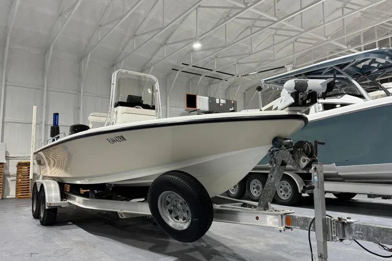 Slide: The Image of 2017 Mako 21 LTS boat on trailer in a spacious indoor storage facility. - 5