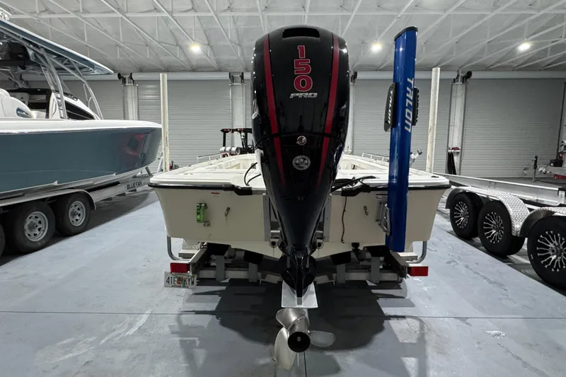 Slide: The Image of 2017 Mako 21 LTS boat with 150 Pro motor in a garage setting. - 7
