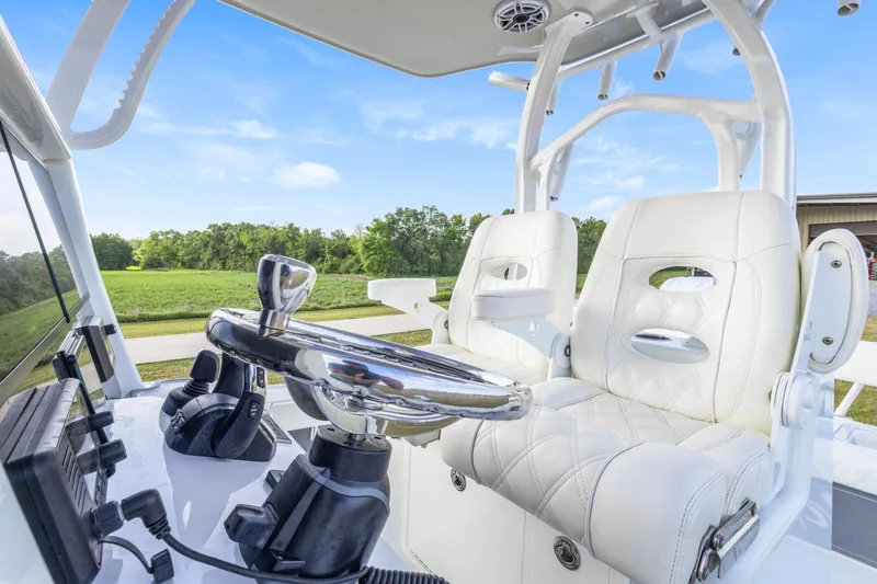 Slide: The Image of 2022 Costa Custom Boats 264 HC helm with white leather seating and modern controls. - 17