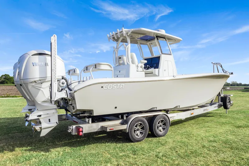 Slide: The Image of 2022 Costa Custom Boats 264 HC on trailer, featuring Yamaha engines, set against a clear blue sky. - 3