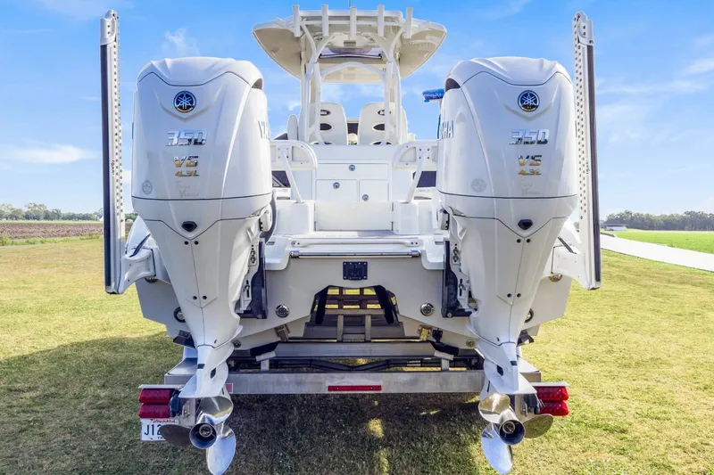 Slide: The Image of 2022 Costa Custom Boats 264 HC with dual Yamaha 350 engines, displayed on grass. - 4