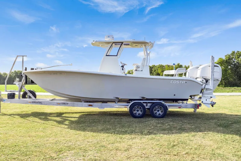 Slide: The Image of 2022 Costa Custom Boats 264 HC on trailer, set against a clear blue sky. - 6