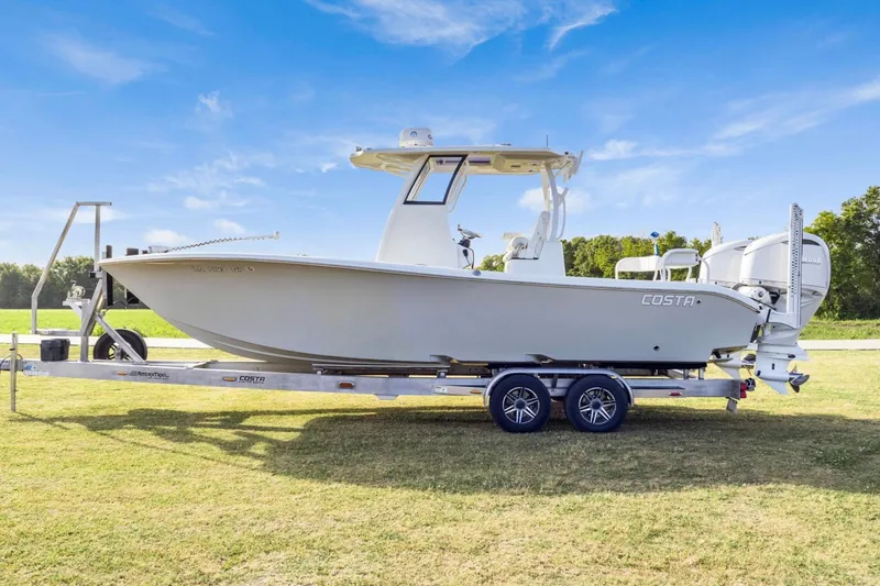 Slide: The Image of 2022 Costa Custom Boats 264 HC on trailer, parked on grass under clear blue sky. - 8