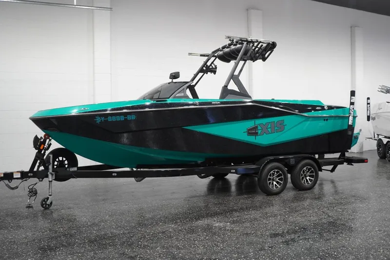 The Image of 2023 Axis T235 boat in showroom, teal and black design on trailer. - 0