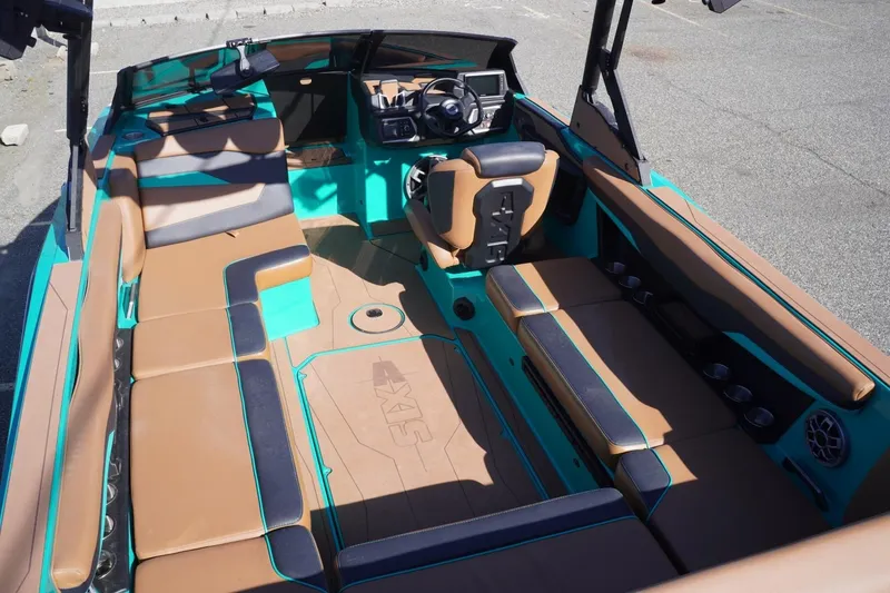 Slide: The Image of 2023 Axis T235 boat interior with brown and teal seating, modern dashboard, and cup holders. - 10