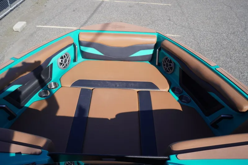 Slide: The Image of 2023 Axis T235 boat interior with brown and teal seating, cup holders, and speakers. - 13