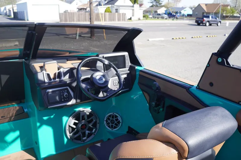 Slide: The Image of 2023 Axis T235 boat interior with steering wheel, dashboard, and speakers. - 14