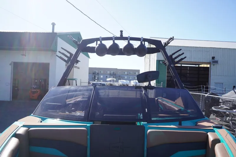 Slide: The Image of 2023 Axis T235 boat with wakeboard tower and speakers, parked outdoors. - 17