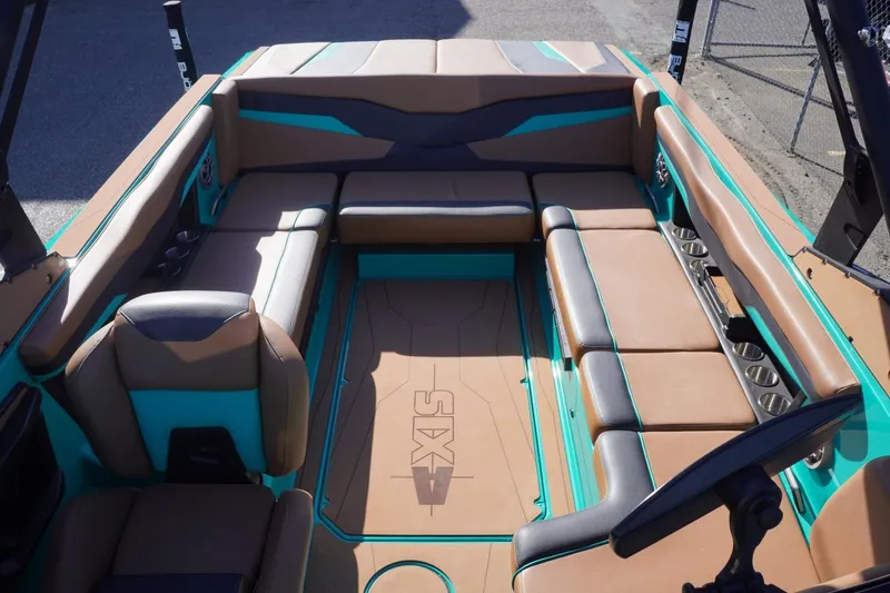 Slide: The Image of 2023 Axis T235 boat interior with brown and teal seating, cup holders, and steering console. - 25