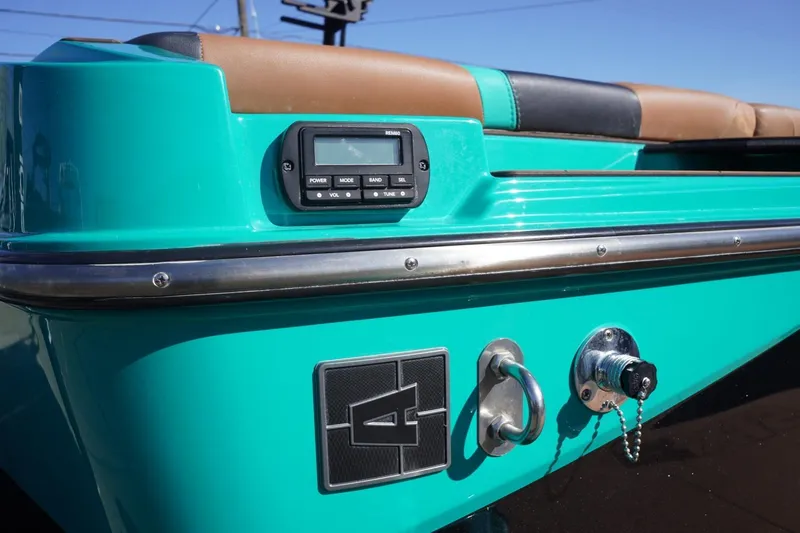 Slide: The Image of 2023 Axis T235 boat, turquoise exterior, featuring control panel and seating. - 7