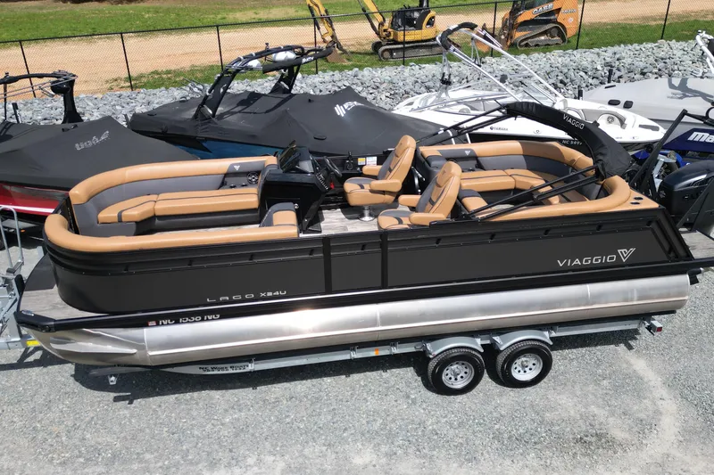 The Image of 2025 Viaggio Lago X-U 24 pontoon boat with tan seating on a trailer. - 0