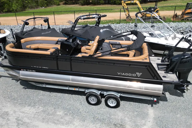 Slide: The Image of 2025 Viaggio Lago X-U 24 pontoon boat with tan seating on a trailer. - 3