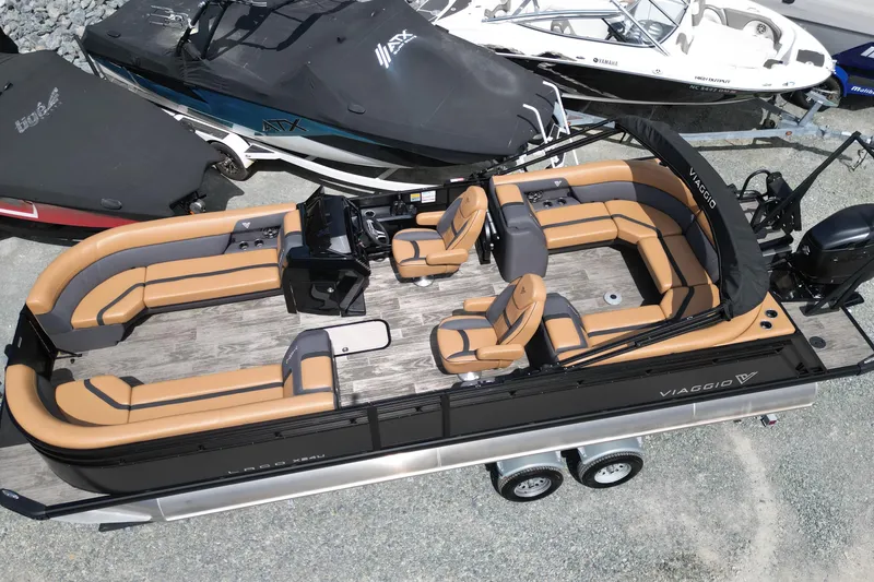 Slide: The Image of 2025 Viaggio Lago X-U 24 pontoon boat with tan seating and sleek design on a trailer. - 6