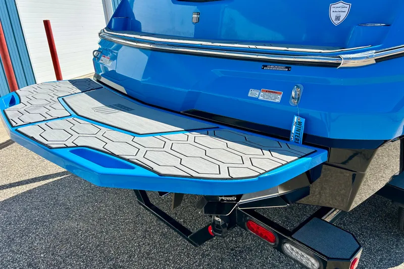 Slide: The Image of 2021 MasterCraft NXT24 boat with blue swim platform and hexagonal pattern design. - 12