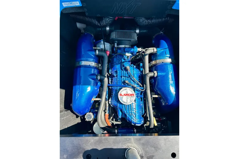 Slide: The Image of 2021 MasterCraft NXT24 Ilmor engine with blue components in boat compartment. - 24