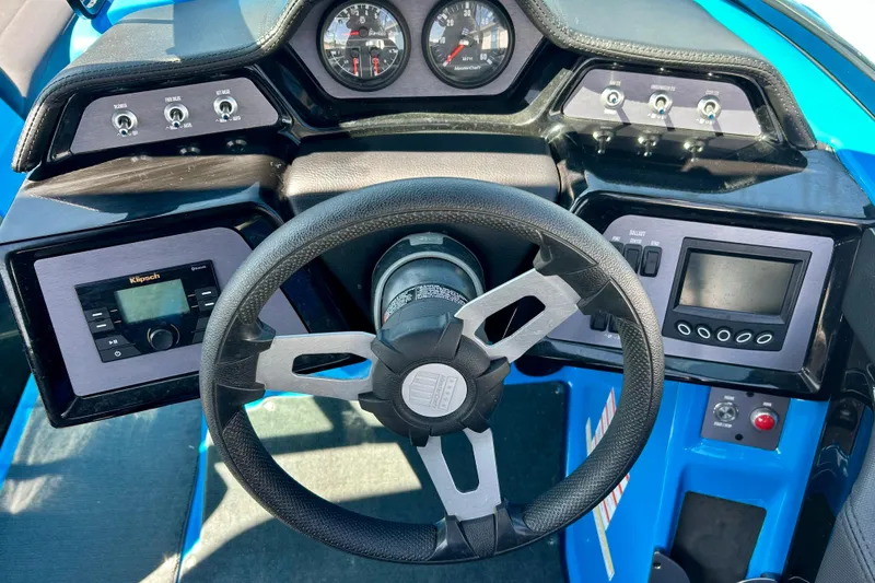 Slide: The Image of 2021 MasterCraft NXT24 boat dashboard with steering wheel and control panels. - 28