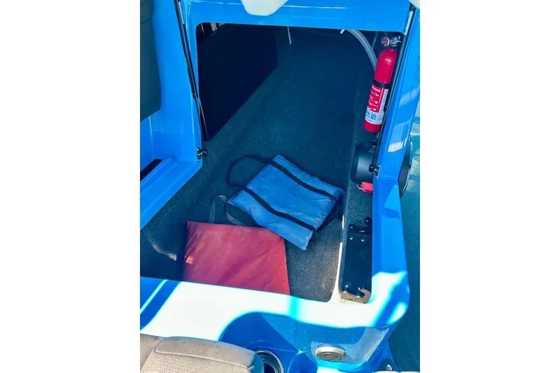 Slide: The Image of Interior storage of 2021 MasterCraft NXT24 boat with safety equipment and bags. - 36